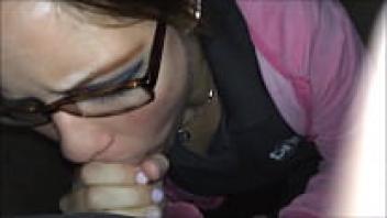 A cute little girl wearing glasses and giving a blowjob