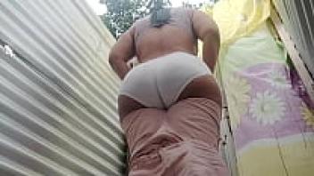 A Latina is caught on video by a pervert in the changing room of a beach.