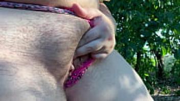 A pregnant MILF wife pumping her own enormous breasts while breastfeeding in a public outdoor setting