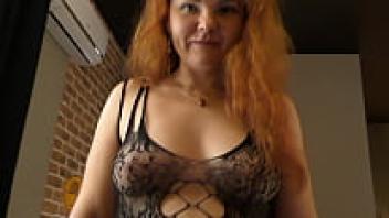 Chubby babe with red hair and a horny appearance rides on cock! Very large natural tits