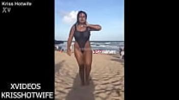 There is a public beach where Kriss Hotwife is showing off her swimsuit, which is see-through.