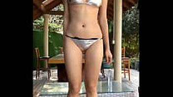 Chic Chinese woman wearing a bikini made of glittering silver latex