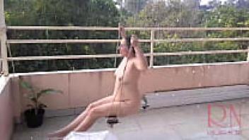 A depraved housewife is seen swinging without her pants on the swings while hiding behind an umbrella from the rain. COMPLETE VIDEO