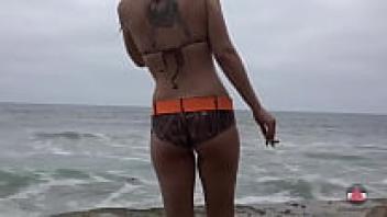While at the beach, smoking a bikini