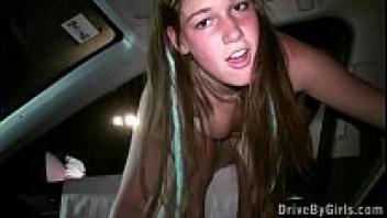 A young blonde adolescent girl's face covered in facial cum during a public gang bang dogging orgy