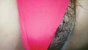 She spreads her legs and hands her hairy pussy with the red thong.